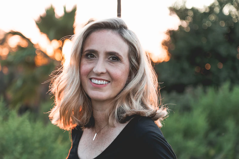 Portrait of a smiling guest with blonde hair backlit by the setting sun